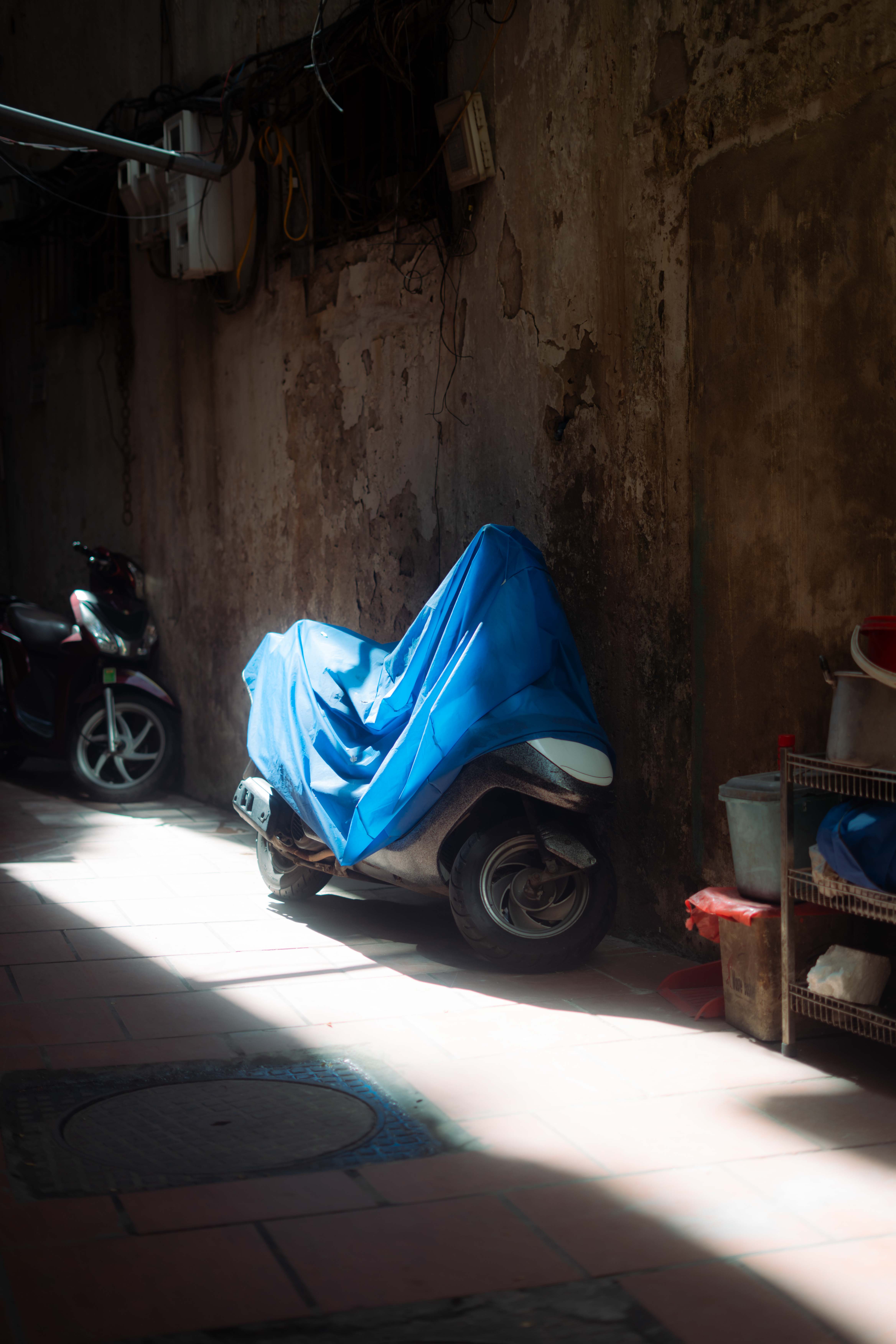 Scooter covered under a tarp, protecting it from the sun's rays
