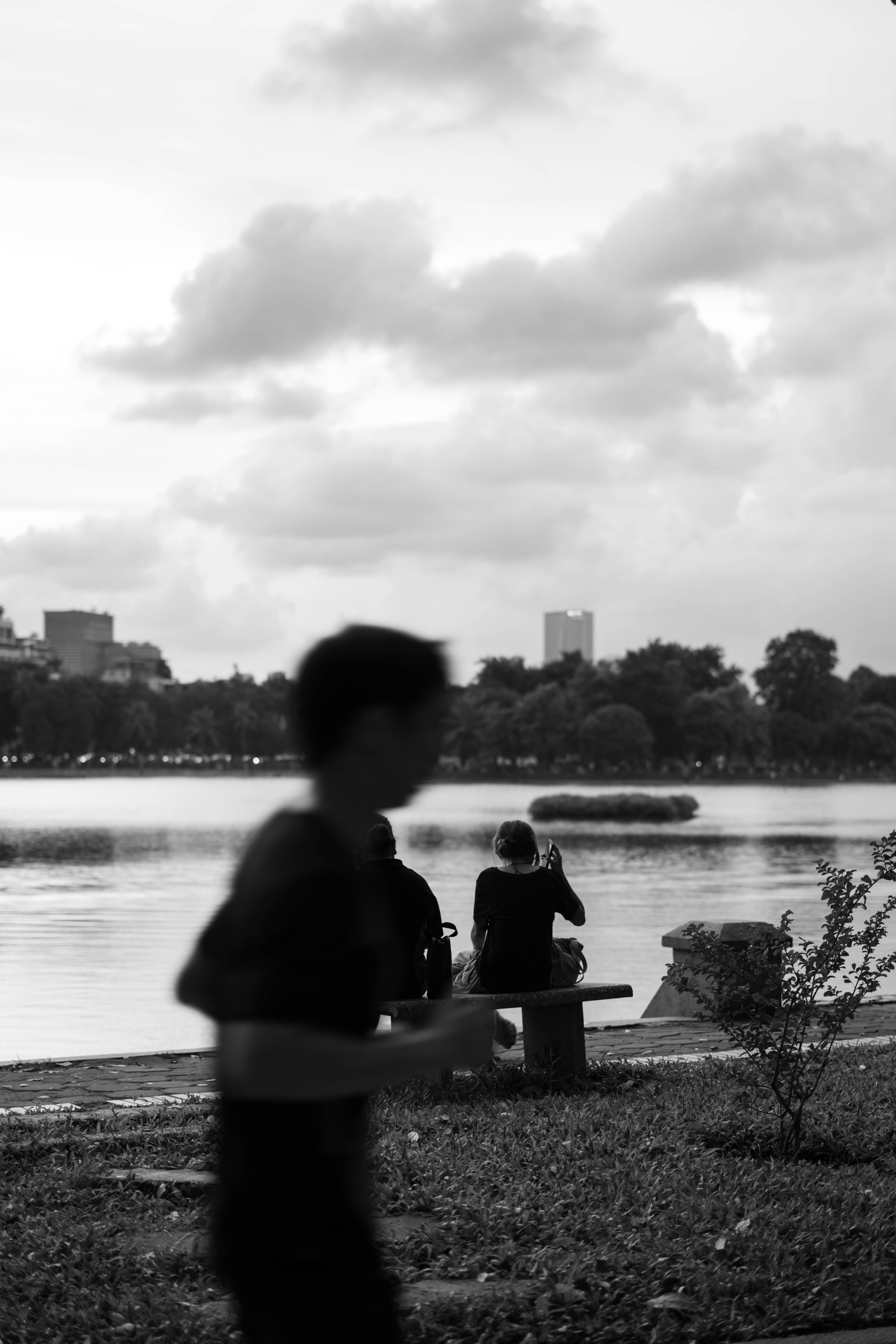 Jogger running past, people resting on the bench behind