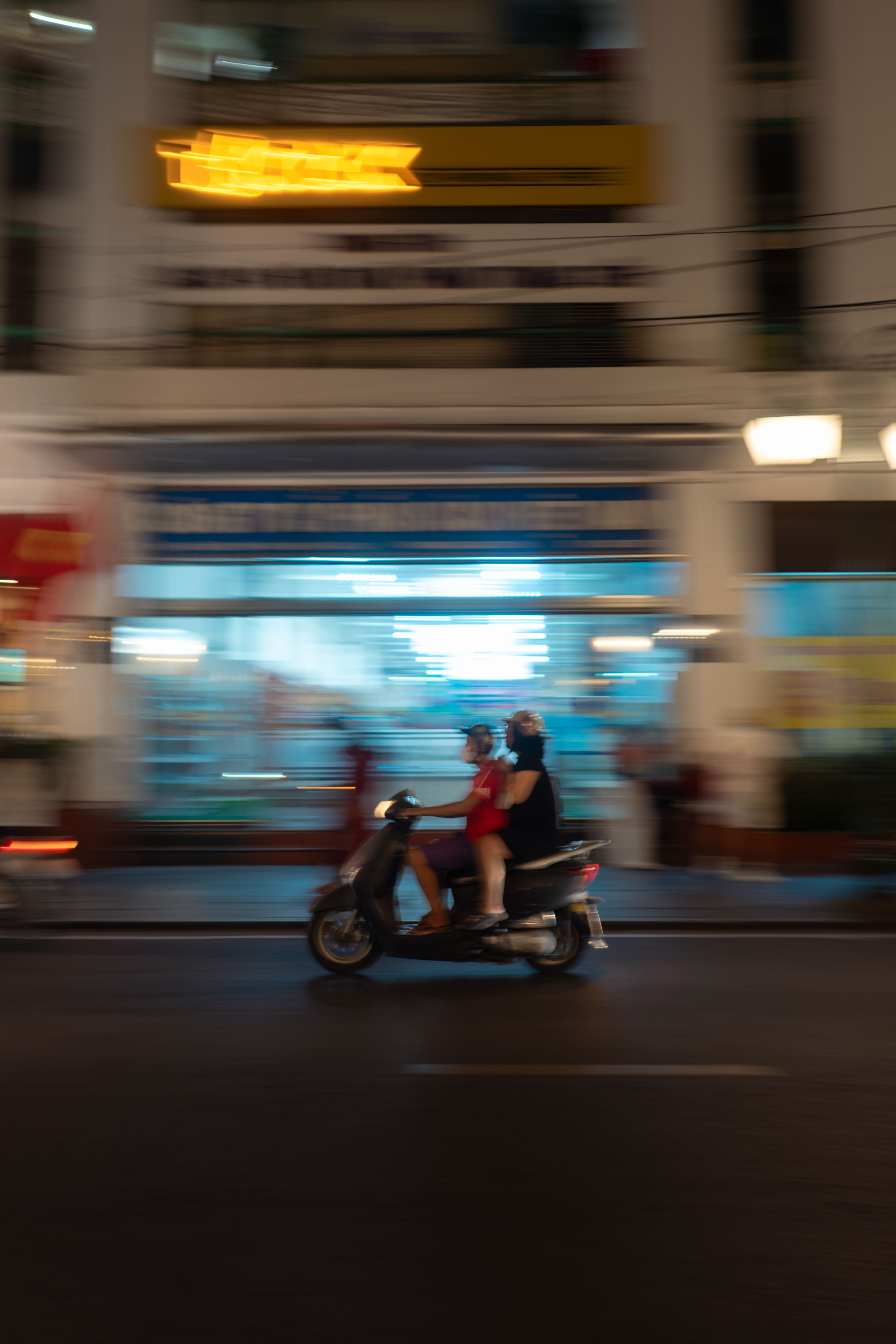 Panning shot of a couple on their trusty scooter